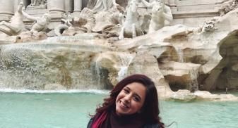 Julia is standing in front of the Trevi Fountain. 